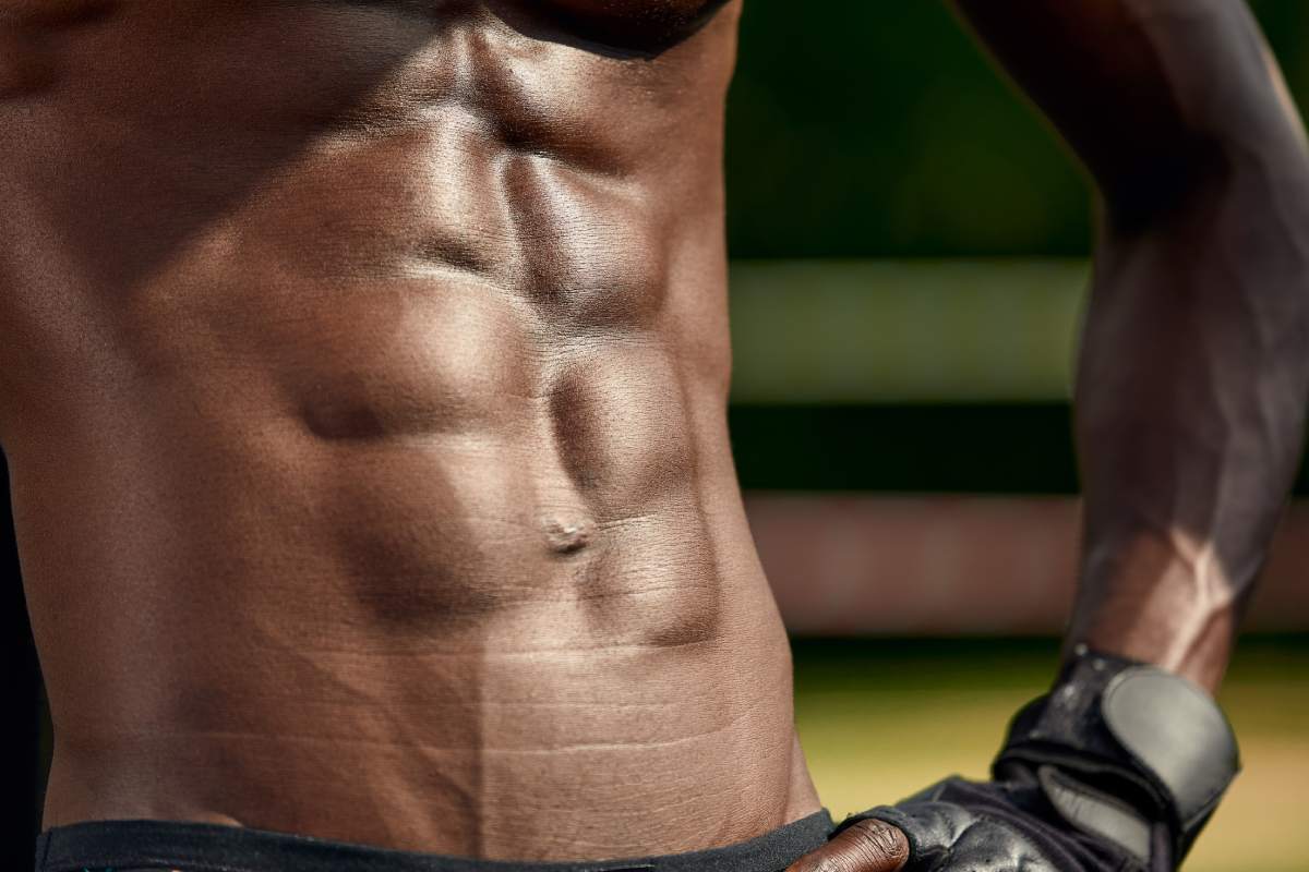 Portrait of black male working out outdoors in a park. He is using a chest machine